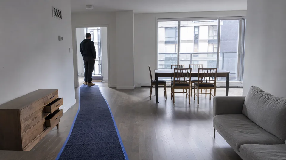 Floor runner taped down a cleared condo hallway with drawers emptied and pathways open before a removal